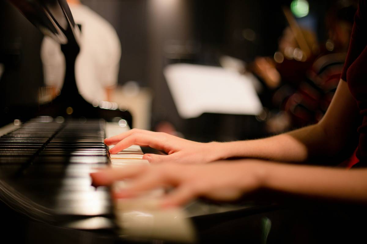 Beginner pianist practicing simple piano exercises for beginners with metronome and chord chart
