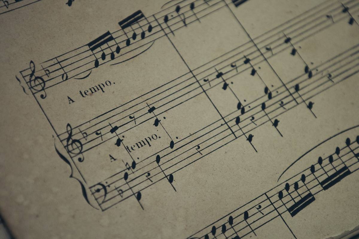 A beginner practicing piano with sheet music labeled 'beginners guide to music theory'