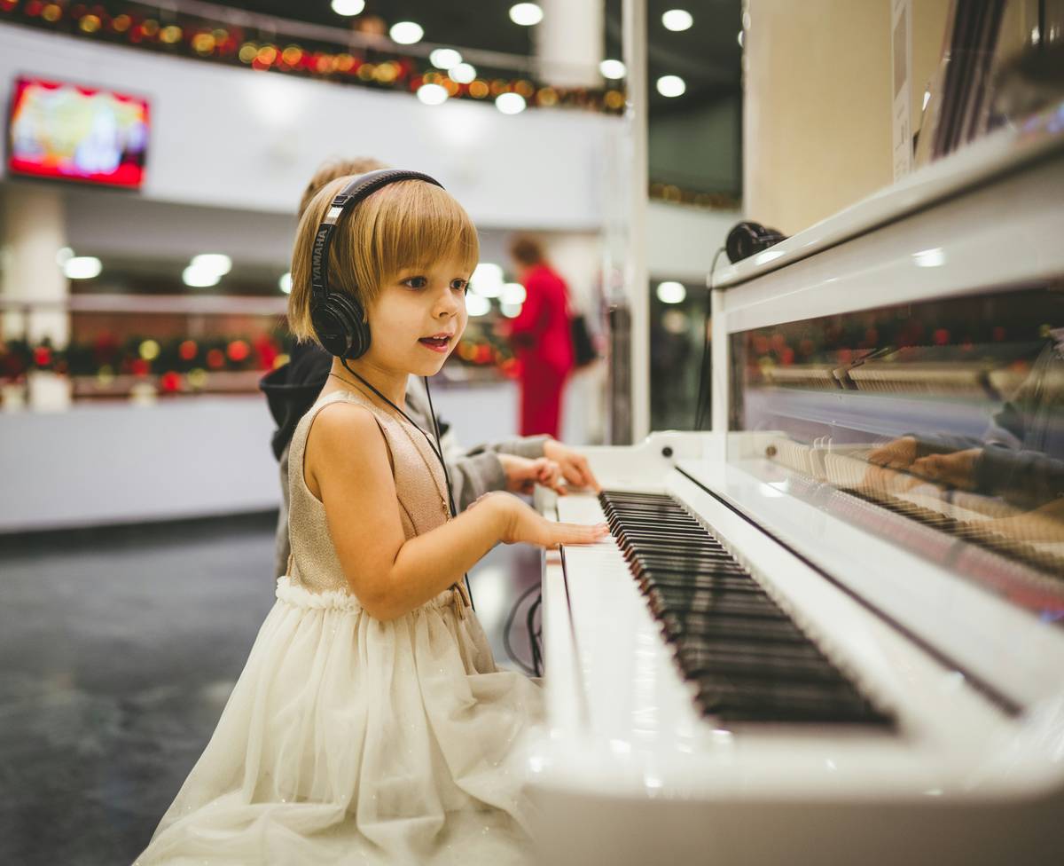 Woman practicing piano lessons techniques with correct hand posture at digital keyboard